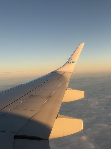 The photo captures a view from an airplane window, showcasing the wing against a vast sky